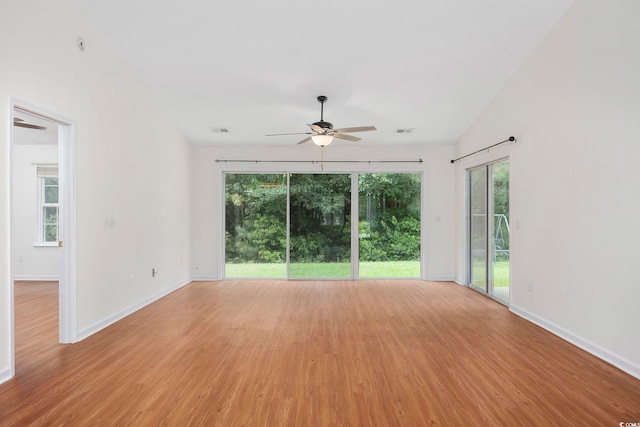 spare room featuring vaulted ceiling, ceiling fan, and light hardwood / wood-style flooring