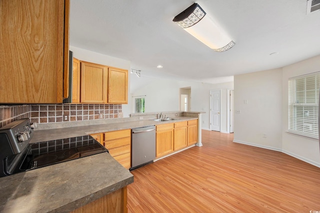 kitchen featuring appliances with stainless steel finishes, a healthy amount of sunlight, light hardwood / wood-style floors, and decorative backsplash