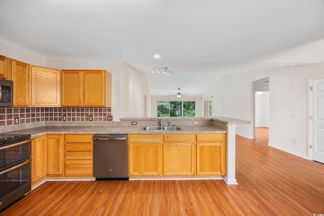 kitchen with dishwasher, lofted ceiling, sink, backsplash, and double oven range