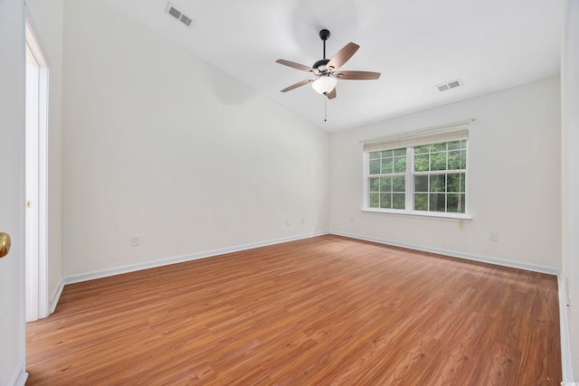 empty room with ceiling fan, vaulted ceiling, and light hardwood / wood-style flooring