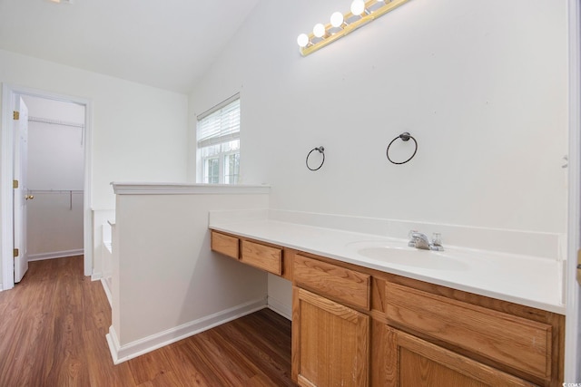 bathroom featuring vanity, hardwood / wood-style flooring, and vaulted ceiling