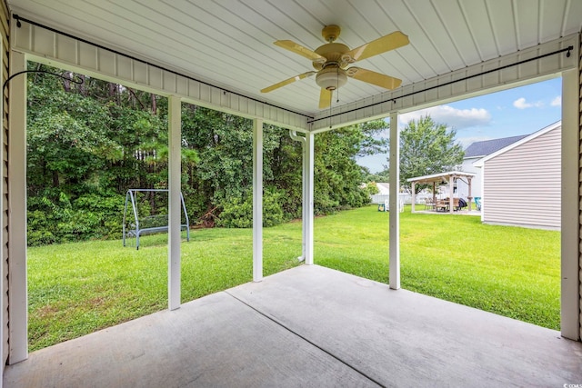 unfurnished sunroom with ceiling fan