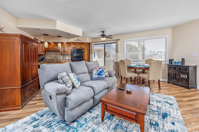 living room with light hardwood / wood-style floors and ceiling fan