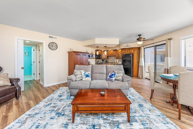 living room featuring light hardwood / wood-style flooring and ceiling fan