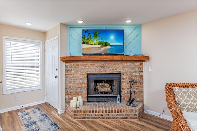 living room featuring hardwood / wood-style floors and a brick fireplace