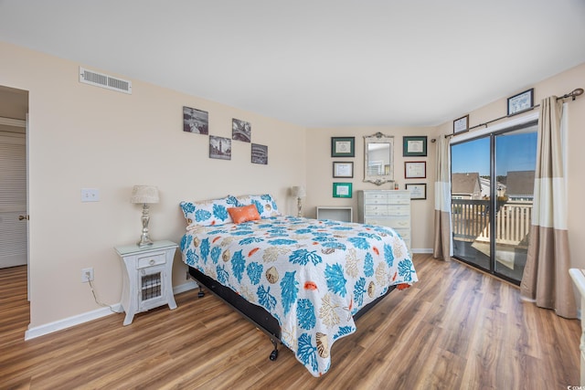 bedroom featuring access to exterior and hardwood / wood-style floors