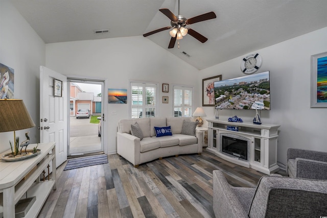 living room with ceiling fan, dark hardwood / wood-style flooring, and high vaulted ceiling