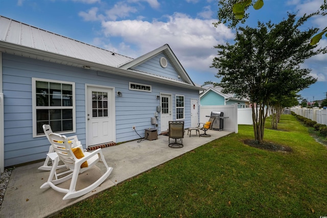 rear view of property featuring a patio and a lawn