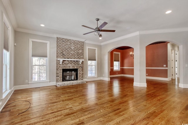 unfurnished living room featuring crown molding, ceiling fan, and wood finished floors