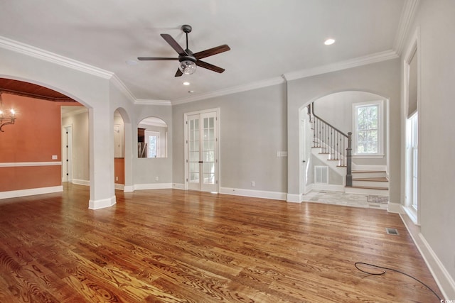 unfurnished living room with visible vents, baseboards, ceiling fan, stairway, and wood finished floors