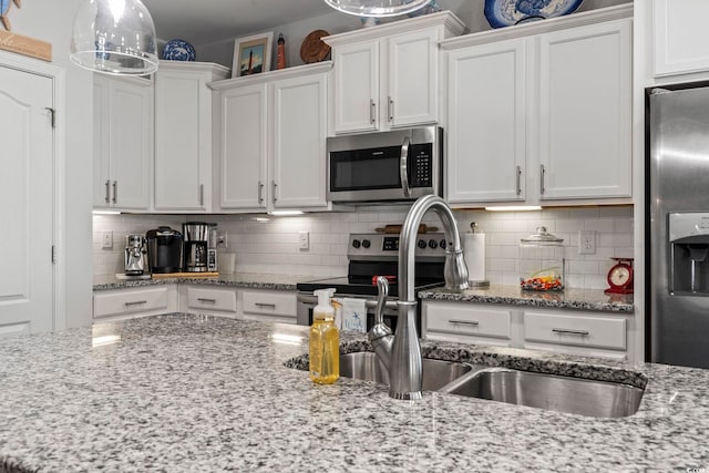 kitchen featuring sink, decorative backsplash, stainless steel appliances, and white cabinets