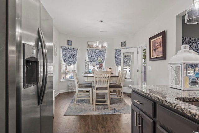 dining space with an inviting chandelier, plenty of natural light, and dark hardwood / wood-style floors