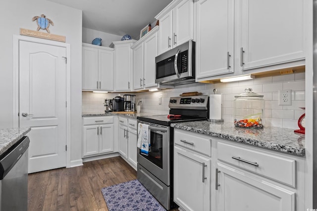 kitchen featuring white cabinetry, appliances with stainless steel finishes, dark hardwood / wood-style floors, and light stone counters