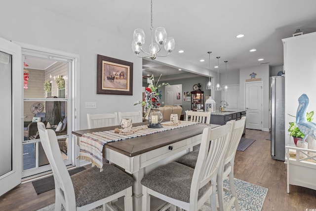 dining space featuring dark hardwood / wood-style floors, sink, and a notable chandelier