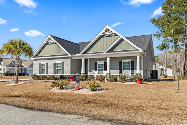 craftsman inspired home featuring central AC, covered porch, and a front lawn