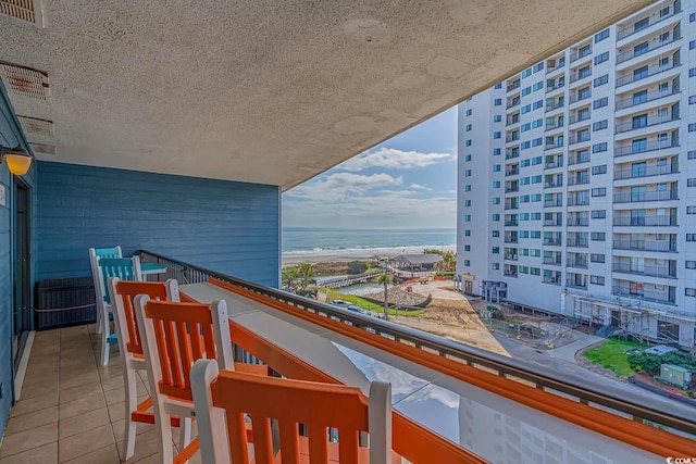 balcony featuring a water view and a view of the beach