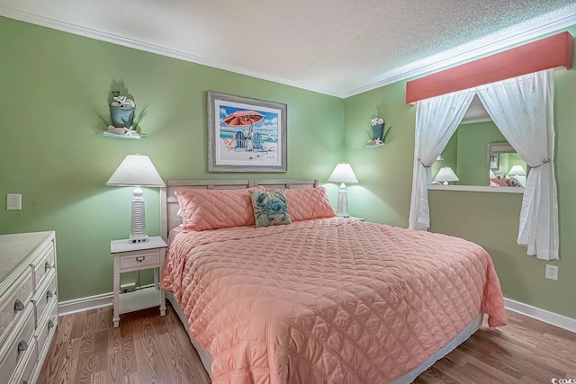 bedroom featuring crown molding, a textured ceiling, and hardwood / wood-style flooring