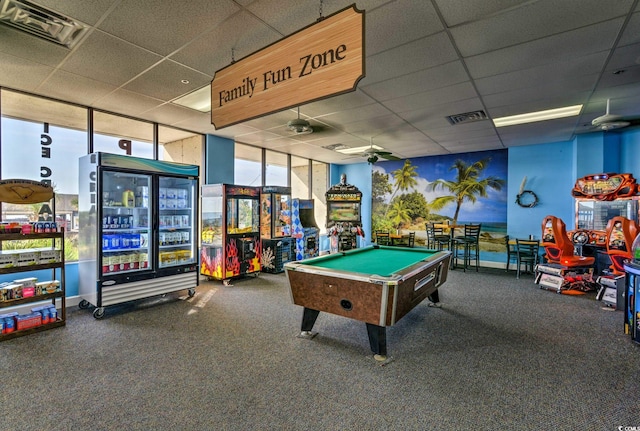 playroom featuring carpet, a paneled ceiling, and a wall of windows