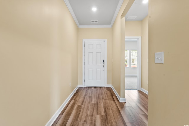 doorway featuring crown molding and hardwood / wood-style flooring