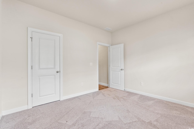 unfurnished room with light carpet