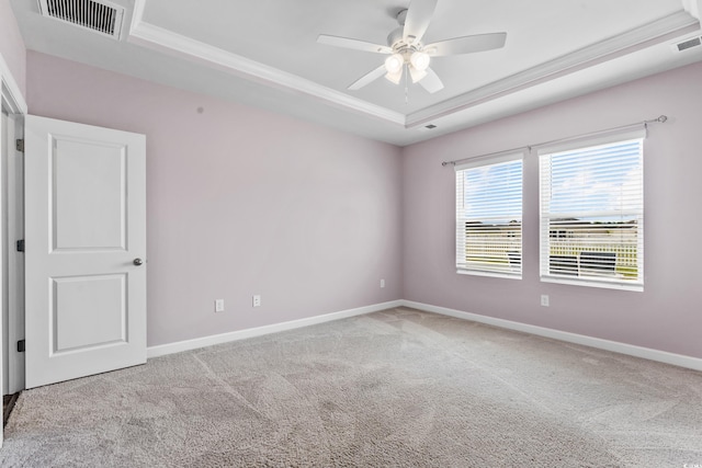 carpeted spare room with ornamental molding, a raised ceiling, and ceiling fan