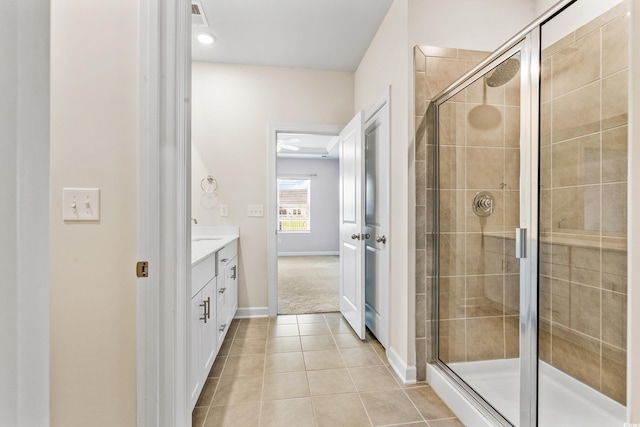 bathroom with vanity, a shower with shower door, and tile patterned floors