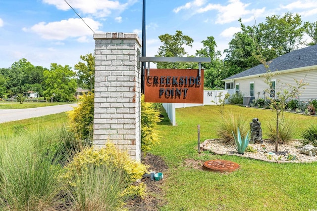 community / neighborhood sign featuring a yard