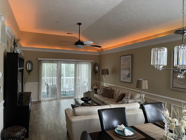 living room with hardwood / wood-style floors, lofted ceiling, ceiling fan, a raised ceiling, and a textured ceiling