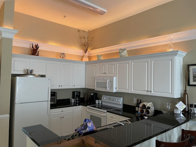 kitchen with white cabinetry, white appliances, and kitchen peninsula