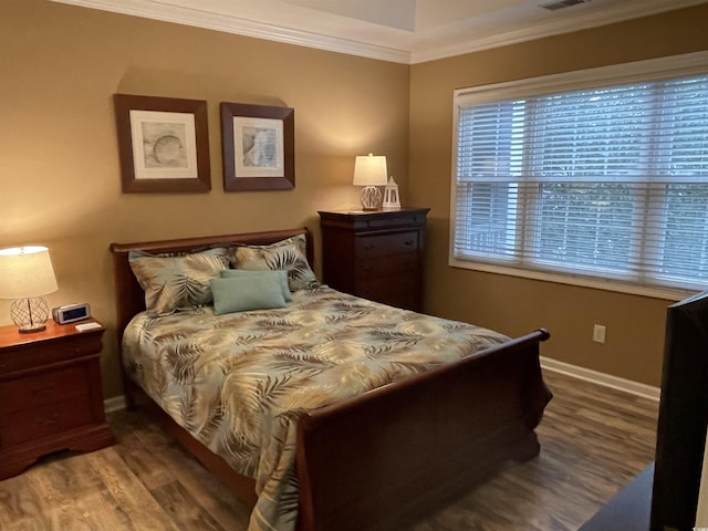 bedroom with crown molding and hardwood / wood-style flooring