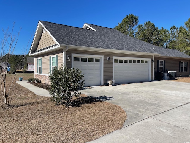 view of side of property with cooling unit and a garage