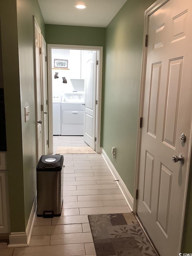 corridor with separate washer and dryer and light wood-type flooring