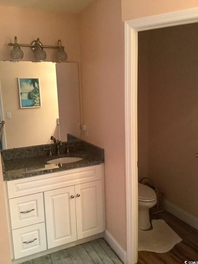 bathroom featuring vanity, hardwood / wood-style floors, and toilet