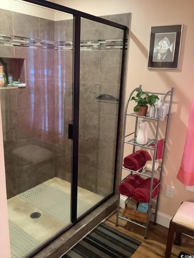 bathroom with hardwood / wood-style floors and a shower with door