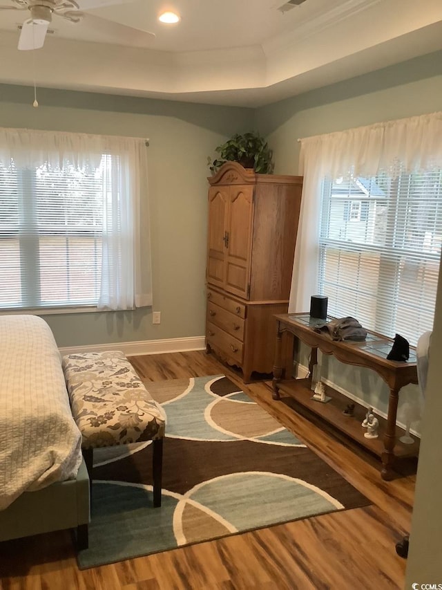 sitting room with a raised ceiling, a healthy amount of sunlight, hardwood / wood-style floors, and ceiling fan