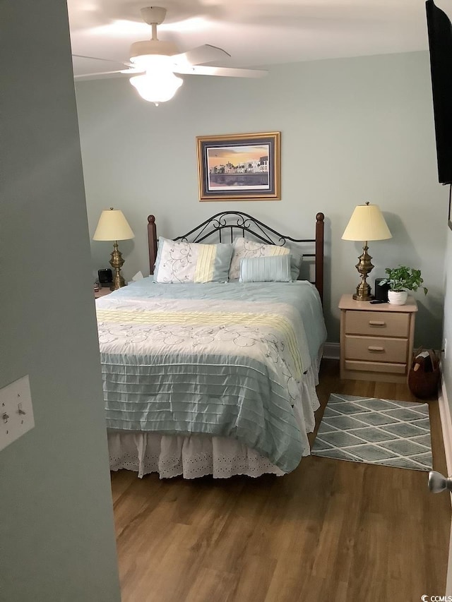 bedroom with ceiling fan and dark hardwood / wood-style flooring