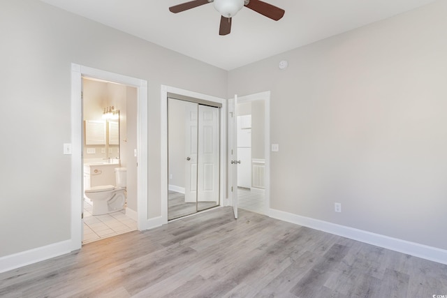 unfurnished bedroom with connected bathroom, light hardwood / wood-style flooring, a closet, and ceiling fan