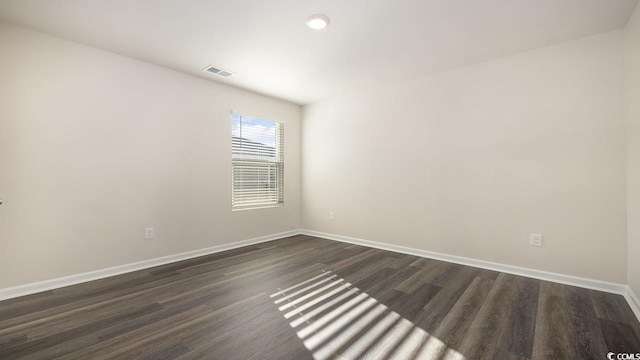 unfurnished room with dark wood-type flooring