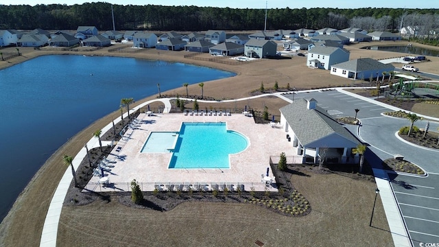 view of pool featuring a water view and a patio