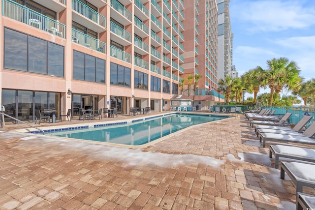 community pool featuring a patio area and fence