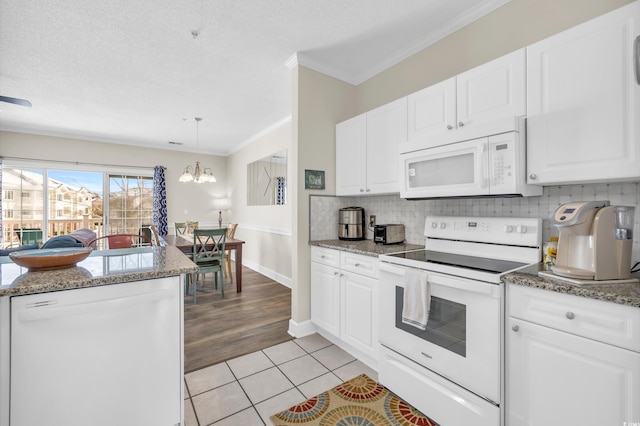 kitchen with white appliances, crown molding, white cabinetry, stone countertops, and light tile patterned flooring