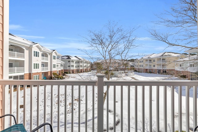 view of snow covered back of property