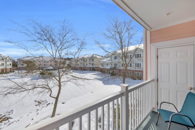 view of snow covered back of property