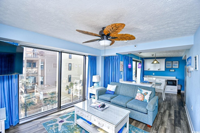 living room featuring ceiling fan, dark hardwood / wood-style floors, and a textured ceiling