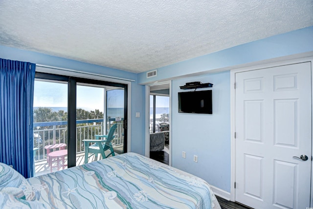 bedroom featuring access to outside and a textured ceiling