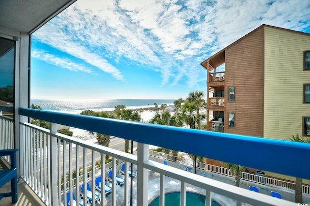 balcony with a water view and a view of the beach