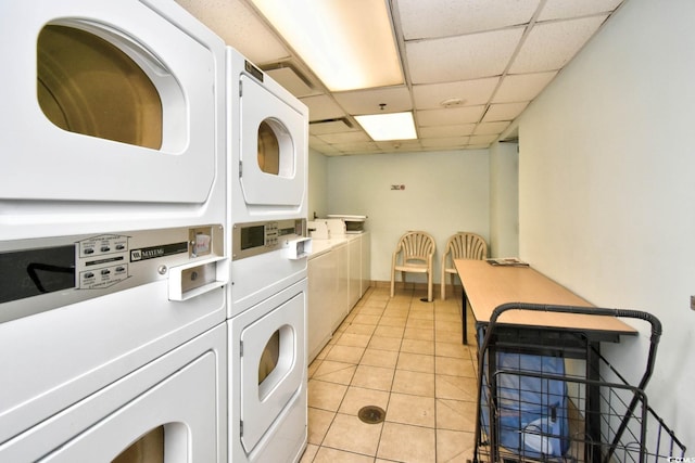 clothes washing area with stacked washer / drying machine, washer and dryer, and light tile patterned flooring