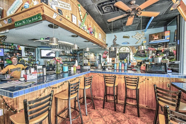 bar featuring tile countertops, tile patterned floors, and ceiling fan