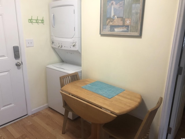 laundry area featuring stacked washer and dryer and hardwood / wood-style floors