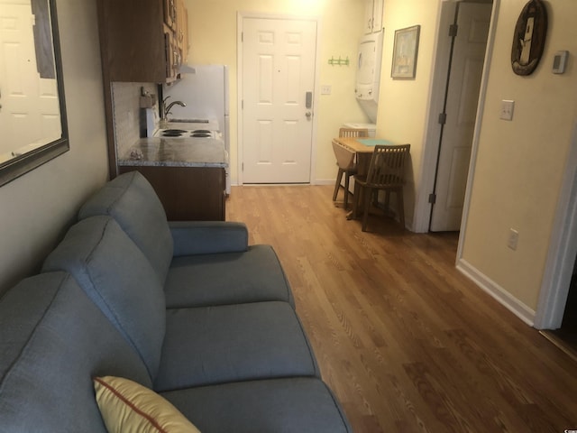 2710 Ocean Blvd S Unit 406, Myrtle Beach, SC 29577 - living area with stacked washing machine and dryer and light wood-type flooring
